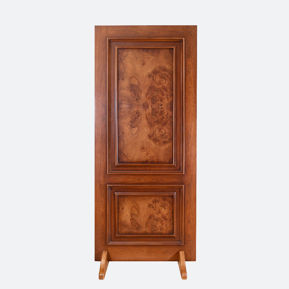 A tall rectangular wooden cabinet or door panel with two inset panels showing rich burl wood grain, photographed upright on a plain light gray background.